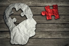 Puzzle head brain concept as a human face profile made from crumpled white paper with a jigsaw piece cut out on a rustic old wood background as a mental health symbol. Puzzle head brain concept as a human face profile made from crumpled white paper with a jigsaw piece cut out on a rustic old wood background as a mental health symbol.